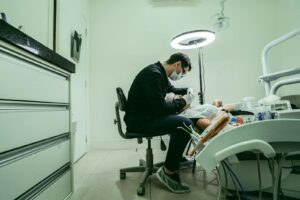 Un dentiste portant un masque soigne un patient dans une clinique dentaire modern.