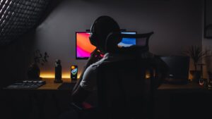 une personne portant des écouteurs assise devant un ordinateur