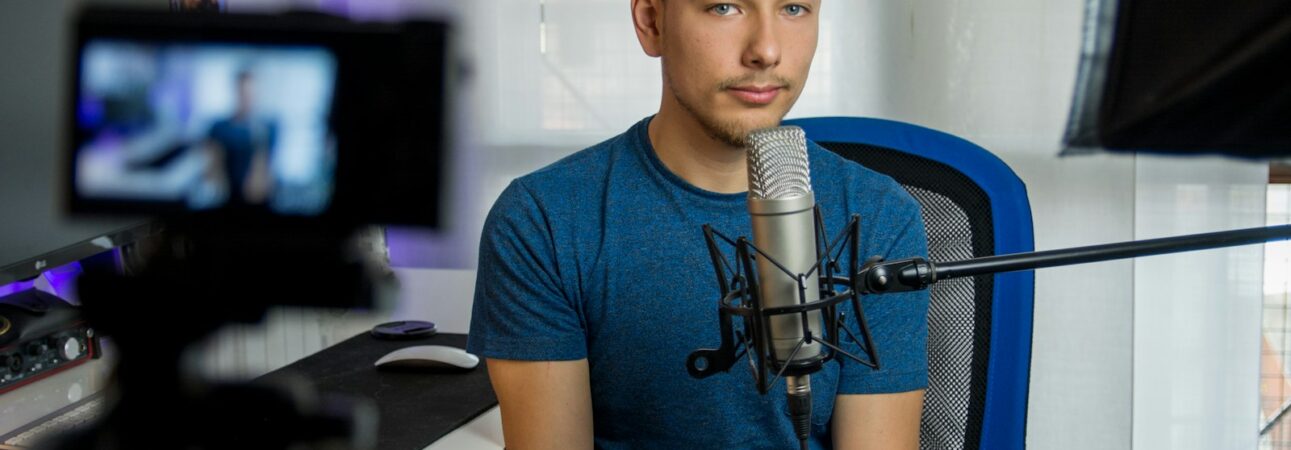 homme assis sur une chaise devant un microphone à condensateur