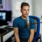 homme assis sur une chaise devant un microphone à condensateur