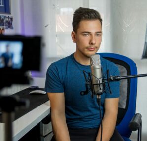 homme assis sur une chaise devant un microphone à condensateur